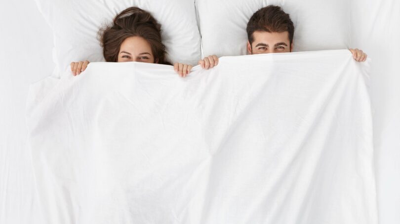 Couple In Bed White Sheets